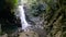 Man at a natural waterfall in the rainforest