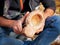 A man in nature carves a kuksa mug from wood. Handmade. Close-up