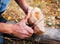 A man in nature carves a kuksa mug from wood. Handmade. Close-up