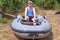 A man in a naval cap sits in a rubber boat standing on the grass. A retired sailor misses the sea