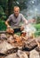 Man near campfire prepare vegetabels for grill