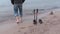 Man near hiking sticks and the edge of the sea