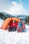 A man near a tent in the winter.