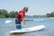 Man next to stand-up paddle board on lake