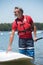 Man next to stand-up paddle board on lake