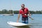 Man next to stand-up paddle board on lake