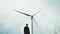 A man next to a wind turbine. Windmill is a symbol of renewable energy