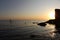 A man with oars on a board in the sea .beautiful sunset on a mountain beach