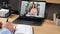 Man at office study online video call laptop listen teacher, writes in notebook