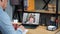 Man at office study online video call laptop listen teacher, writes in notebook