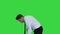 Man in official clother sweeping the floor on a green screen, chroma key.