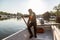 Man in old white boat is rowing in sunrise