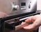 Man opening empty electric oven in kitchen, close up.