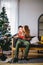 Man opening a gift box while her girlfriend sitting close to her on couch