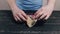 Man opening package with halva on black wooden kitchen table.Unhealthy fat tasty sweets, food, diet, nutrition, overweight concept