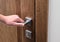 The man opens the door. Close - up of hand and door handle, white wall