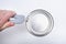 A man opens a jar of white paint with a can opener on a white background. Renovation