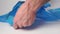Man opens a new plastic blue garbage bag close-up