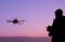 Man operating a drone with remote control. Dark silhouette again