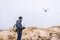 Man operating a drone while trekking on beach