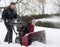 Man operating snow blower