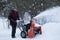 Man Operating Snow Blower on a Stormy Winter`s Day
