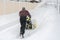 Man operating snow blower to remove snow on driveway. Man using a snowblower. A man cleans snow from sidewalks with