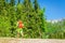 Man with orange backpack walks in mountains