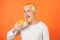 Man with orange juice on orange background. Close up portrait young man holding glass orange juice. Juicy orange.