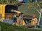 Man in orange safety vest and orange hard hat operating tree chipper