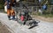 Man in orange uniform using vibrational paving stone machine for finish on a sidewalk road construction site.