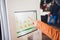 A man orders food in the touch screen terminal with electronic menu in fast food restaurant.