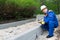 A man in overalls holds notes on the work done during the repair of walking roads in the park