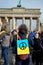 Man with packard on his back. Pacific sign with English text No War on Ukrainian yellow blue flag. Anti war protest in