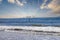 A man on a paddle board in the vast blue ocean water with blue sky and clouds at Rincon Beach in Ventura County