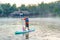 man on Paddleboard or sup board in middle of lake and enjoying sunrise and fog in the morning