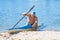 Man paddling a blue and yellow kayak on the river near the shore. Kayaking concept.A man swims in a canoe on the river.