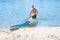 Man paddling a blue and yellow kayak on the river near the shore. Kayaking concept.A man swims in a canoe on the river.