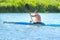 Man paddling a blue and yellow kayak on the river near the shore. Kayaking concept.A man swims in a canoe on the river.