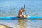 Man paddling a blue and yellow kayak on the river near the shore. Kayaking concept.A man swims in a canoe on the river.