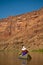 Man paddling canoe in desert canyon river