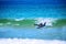 Man paddling in the sea to catch wave on surfboard