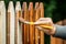 Man is paint wooden fence at backyard