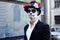 A man with a painted face of a skeleton, a dead zombie, in the city during the day. day of all souls, day of the dead, halloween,