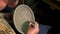 Man painting clay bowl in pottery workshop.