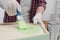 Man painting honeycomb shaped shelf with brush indoors, closeup