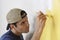 Man Painting Yellow Color On Wall