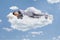 Man in pajamas sleeping on clouds and floating in the sky