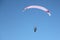 Man with a parachute and a motor flying in the blue sky