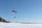 Man with a parachute and a motor, flying in the sky on a winter